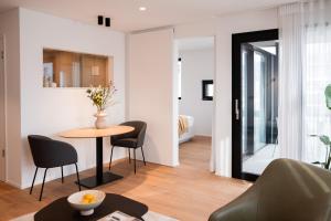 a living room with a table and chairs and a bedroom at THE FLAG Lugano - Self Check-in in Massagno