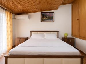 a bedroom with a bed with a wooden ceiling at Villa Hodo in Vlorë