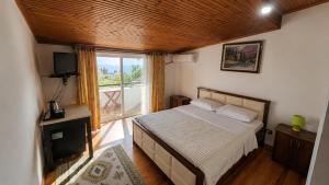 a bedroom with a bed and a large window at Villa Hodo in Vlorë