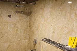 a shower with a glass door in a bathroom at Briddhishree Palace in Guwahati +22 photos