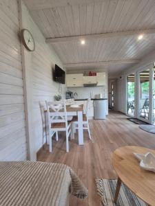 a kitchen and living room with a table and chairs at Holiday Resort Zakątek Łeba in Łeba +36 photos