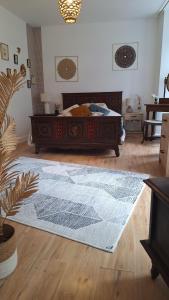 a bedroom with a bed and a rug on the floor at Libre comme l'air - Appartement - Terrasse - 1 Chambre in Ruffec