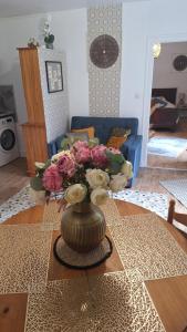 a vase with flowers on a table in a living room at Libre comme l'air - Appartement - Terrasse - 1 Chambre in Ruffec