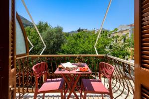 a table with a bowl of fruit on a balcony at Pinotsi Rooms Village Symi in Symi