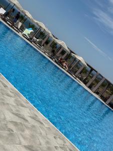 a swimming pool with chairs next to a pier at Helis Bodrum Residence in Milas