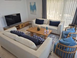 a living room with two couches and a television at Helis Bodrum Residence in Milas