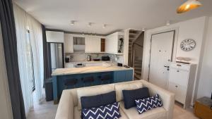 a living room with a couch and a kitchen at Helis Bodrum Residence in Milas