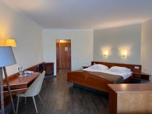 a hotel room with a bed and a desk at Hotel Lorösch in Bad Orb +67 photos