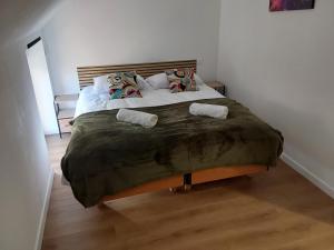 a bedroom with a large bed with two pillows at Aux Cormulets in La Baconnière