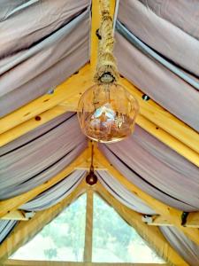 a glass chandelier hanging from the ceiling of a tent at Glamping Casacocco' in San Ginesio +2 photos
