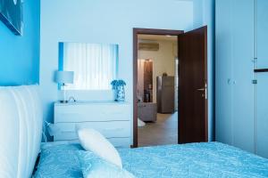 a blue bedroom with a bed and a dresser at El Prestinée Box auto gratuito in Milan
