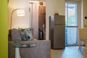 a living room with a couch and a refrigerator at El Prestinée Box auto gratuito in Milan