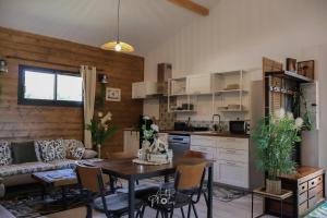 a kitchen and living room with a table and a couch at Chalet tous confort avec piscine lagon in Vallon-Pont-dʼArc