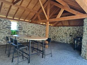 a table and chairs in a room with a stone wall at le Cocon in Montgardin