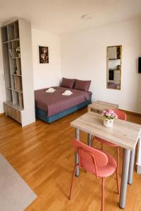a room with a bed and a table and a bed sidx sidx sidx at Rose casa apartments Vrnjacka Banja in Vrnjci