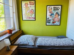 a bedroom with two posters on a green wall at Gemütliches Haus im grünen in NFO in Niederfinow