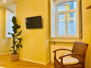 a room with a chair and a television on a wall at Santa Cruz - B&B in Lagos