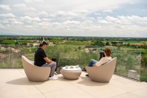 a group of three people sitting in chairs on a balcony at Il Parnaso Relais in Longare