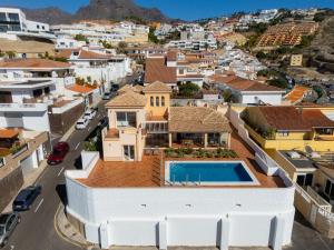 a house with a swimming pool in the middle of a city at Villa Evita Private Pool, Jacuzzi & Sea views in Adeje