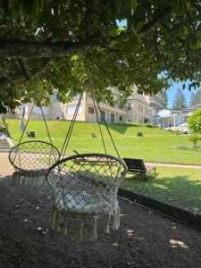 two swings hanging from a tree in a park at Hotel Bel Air Trail & Wellness in Echternach