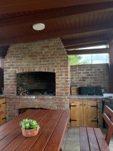 a patio with a brick fireplace and a wooden table at Apartma Lavanda in Zavrč