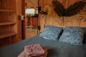 a bedroom with a bed with two blue pillows at Tente chauffée avec piscine lagon in Vallon-Pont-dʼArc