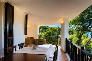 a dining room with a table and chairs on a balcony at Catalina, ritorno al '70 tra mare e natura in Cannigione