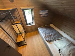 a small room with a bed and a ladder at Nisserstrand Hytte mit WLAN und Sauna direkt am See in Treungen