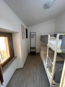 a room with two bunk beds and a window at LA CASETTA di AURORA in Riomagno