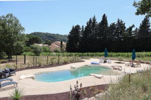 a swimming pool in a yard with lounge chairs at Tente chauffée avec piscine lagon in Vallon-Pont-dʼArc +11 photos