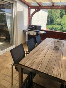 a table and chairs in a room with a grill at Ferienwohnung Weitblick in Rodalben +23 photos