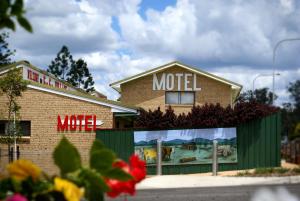 una señal de motel en el lateral de un edificio en Gin Gin Village Motor Inn Motel QLD en Gin Gin