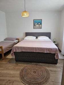 a bedroom with two beds and a rug on the floor at Apartman sunny green in Sveti Juraj +17 photos