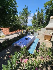 a patio with a table and two blue beds at Apartman sunny green in Sveti Juraj