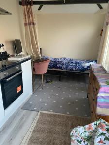 a small room with a bed and a desk and a desk at Keethz Home in Timperley