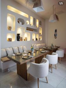 a dining room with a table and white chairs at Suites Hôtel Les Charmilles & Spa in Tunis +55 photos