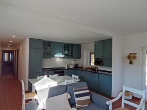 a kitchen with green cabinets and a white table at Typical Alentejo House in Mora
