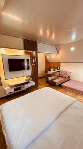 a bedroom with a large bed with a flat screen tv at villa cabin vianda in Kejajar