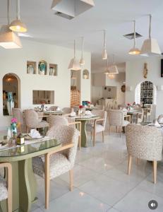 a dining room with tables and chairs and pendant lights at Suites Hôtel Les Charmilles & Spa in Tunis