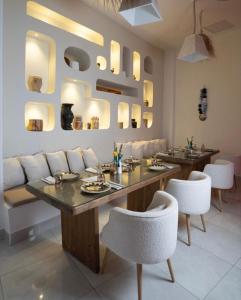 a dining room with a table and white chairs at Suites Hôtel Les Charmilles & Spa in Tunis