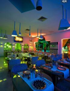 a restaurant with tables and blue chairs and lights at Suites Hôtel Les Charmilles & Spa in Tunis