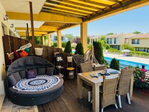 a patio with a table and chairs and a pergola at Arapya Beach Apartment in Tsarevo