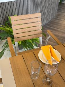 a wooden table with a plate and glasses on it at The Lamendriea Hotel in Kalagedihena