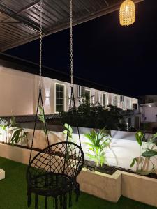 a chair hanging from a chain in a patio at night at The Lamendriea Hotel in Kalagedihena