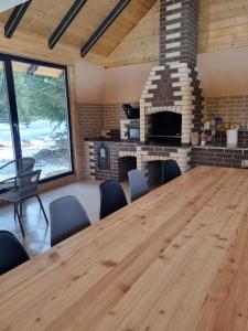 a conference room with a large wooden table and a fireplace at Cabana dintre brazi Mărișel in Dealu Negru