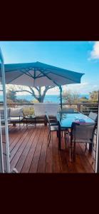 a blue table and chairs on a deck with an umbrella at Premium Sea View in Saint-Raphaël