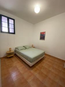 a bedroom with a bed in a white room at APPARTEMENT Malana in Nîmes