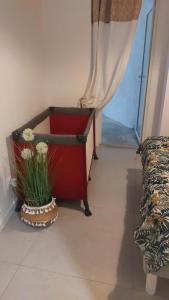 a red dresser with a vase of flowers next to a window at Le patio de la place in Saint-André-de-Sangonis