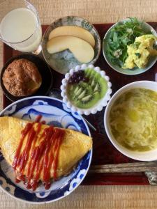 a table topped with bowls of food and a plate of food at YAMABE BOSSA inn in Matsumoto