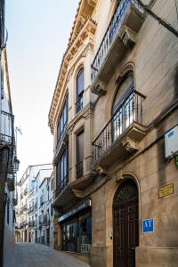a building with balconies on the side of a street at Apartamentos 4Duques in Cáceres